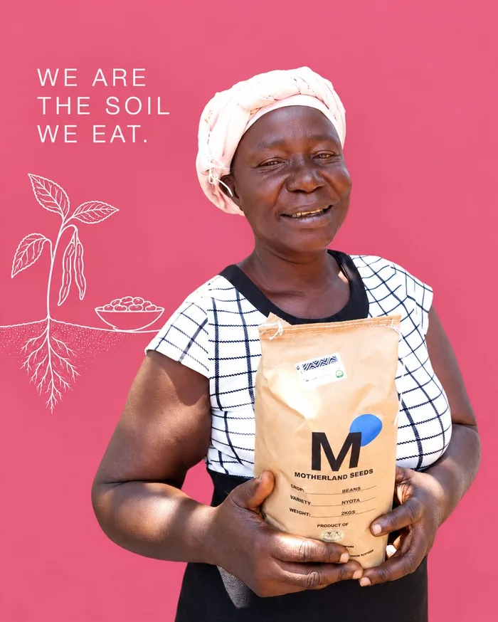 Bäuerin mit weißer Mütze und einer Tüte MOTHERLAND SEEDS vor pinkem Hintergrund, Siaya, Kenia